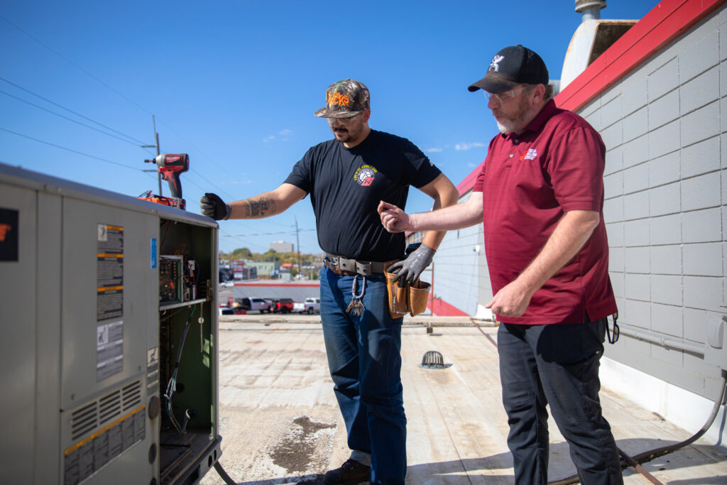 HVAC professionals working on rooftop unit