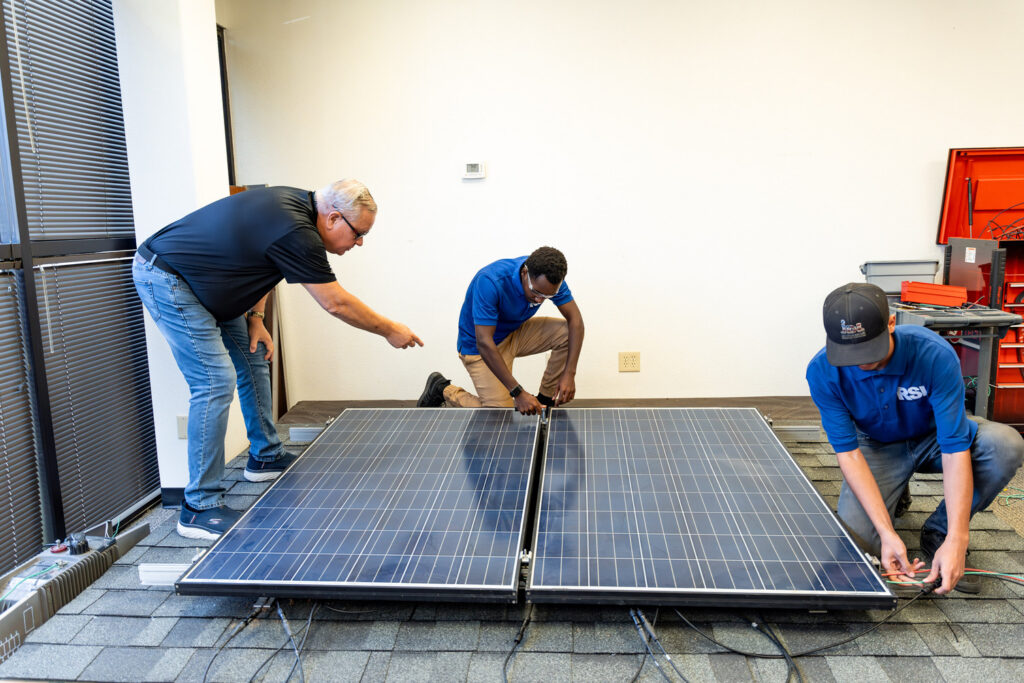 Three RSI students working on a solar panel