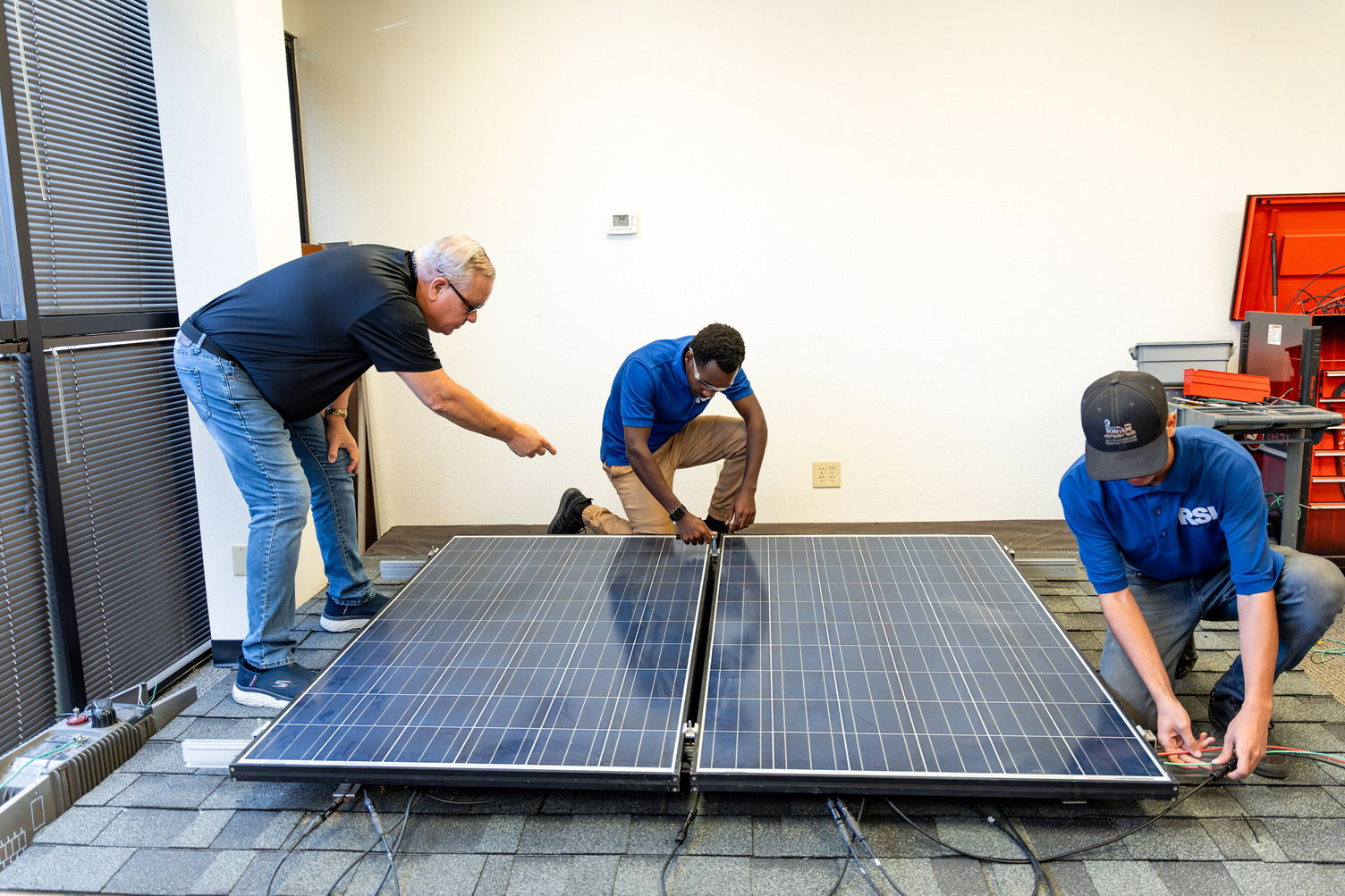 Three RSI students working on a solar panel
